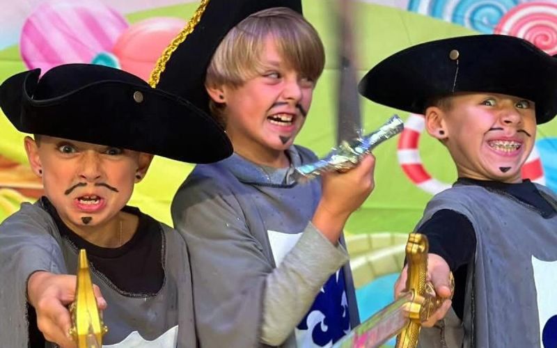 three boys play acting as muskateers